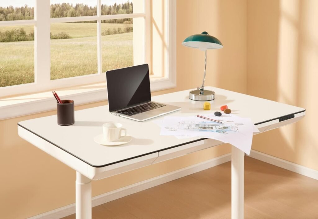 Modern home office desk setup with adjustable desk lamp, laptop, notebook, and coffee cup for a productive workspace.
