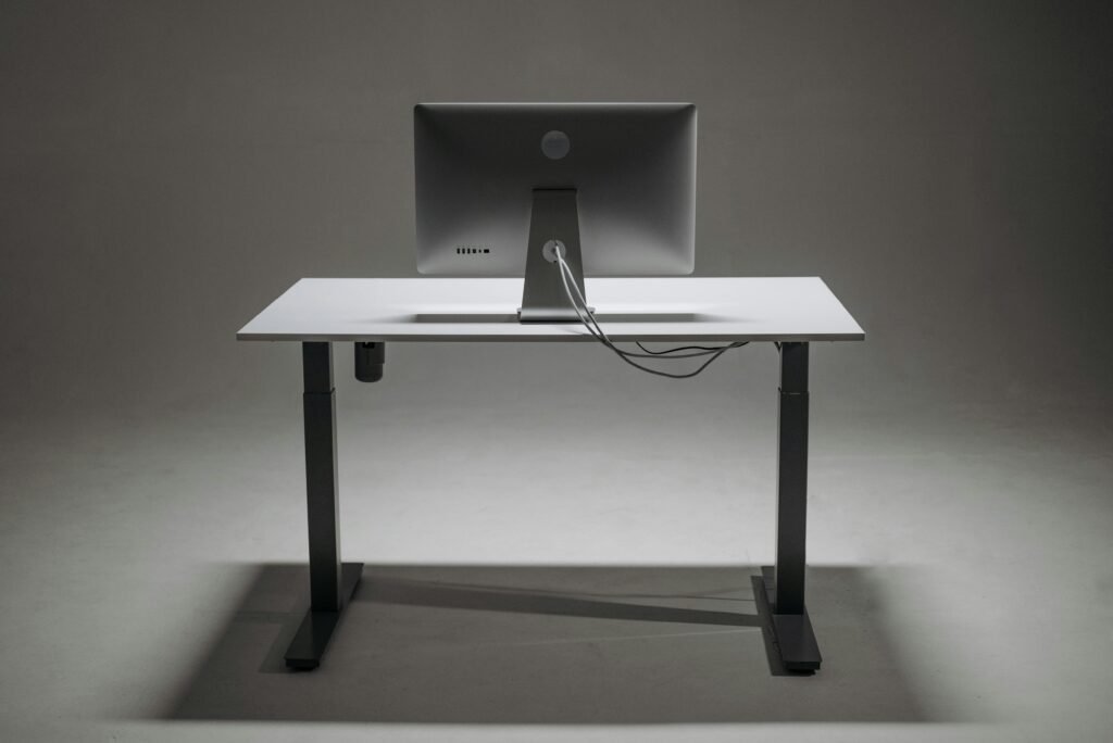 Electric standing desk with motorized height adjustment and dual screen setup