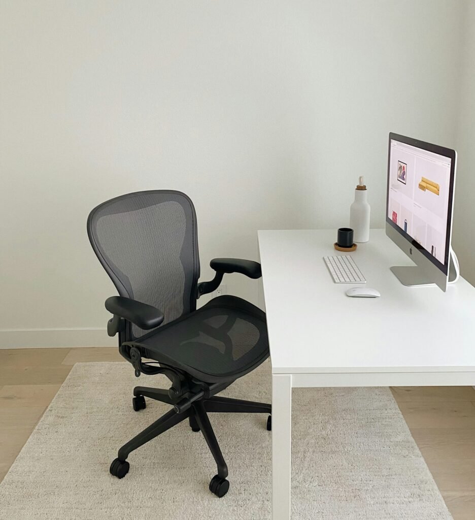 Simple black ergonomic chair placed against a white wall