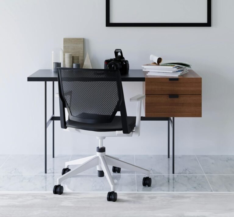 Sleek, minimalist black desk setup with a chair, laptop, and tidy accessories